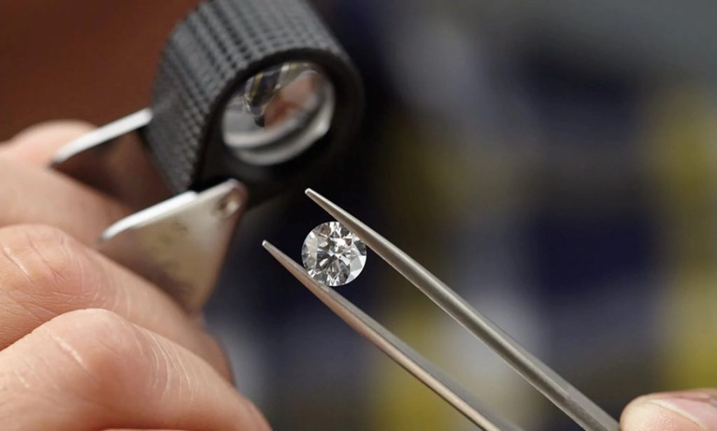 Natural diamond held in tweezers for trade inspection